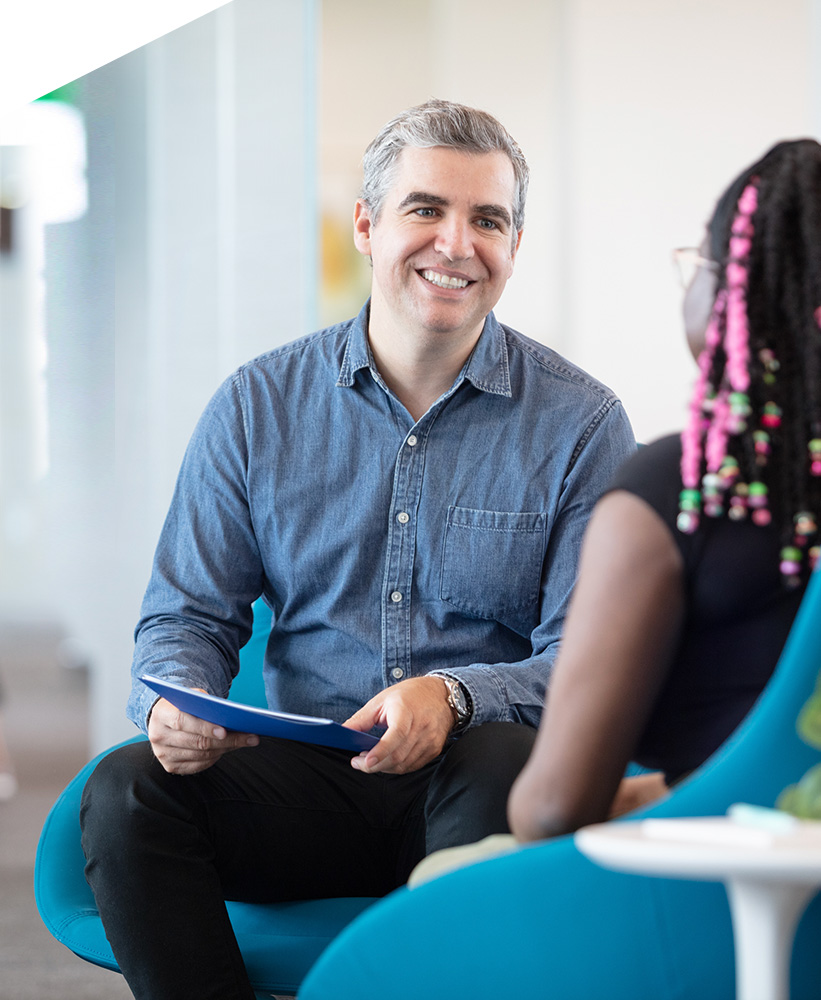 A man and a young woman sitting and having a discussion.