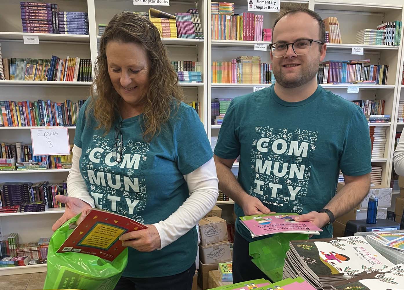 Two Ascendium employees organzing childrens books. 