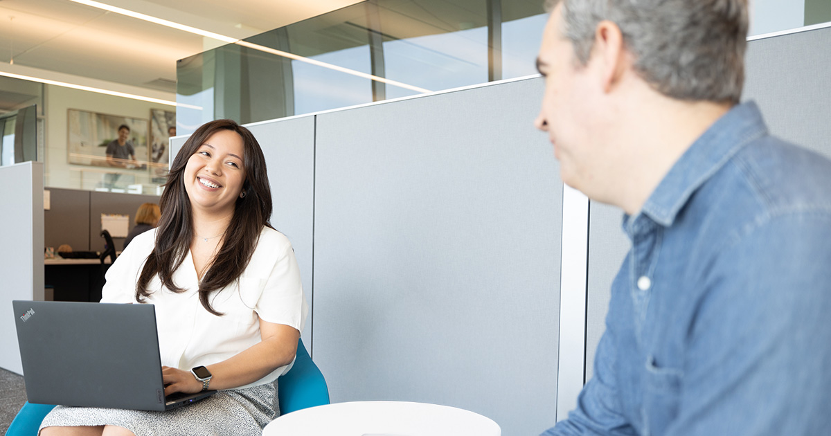 Two employees working together at a laptop. 